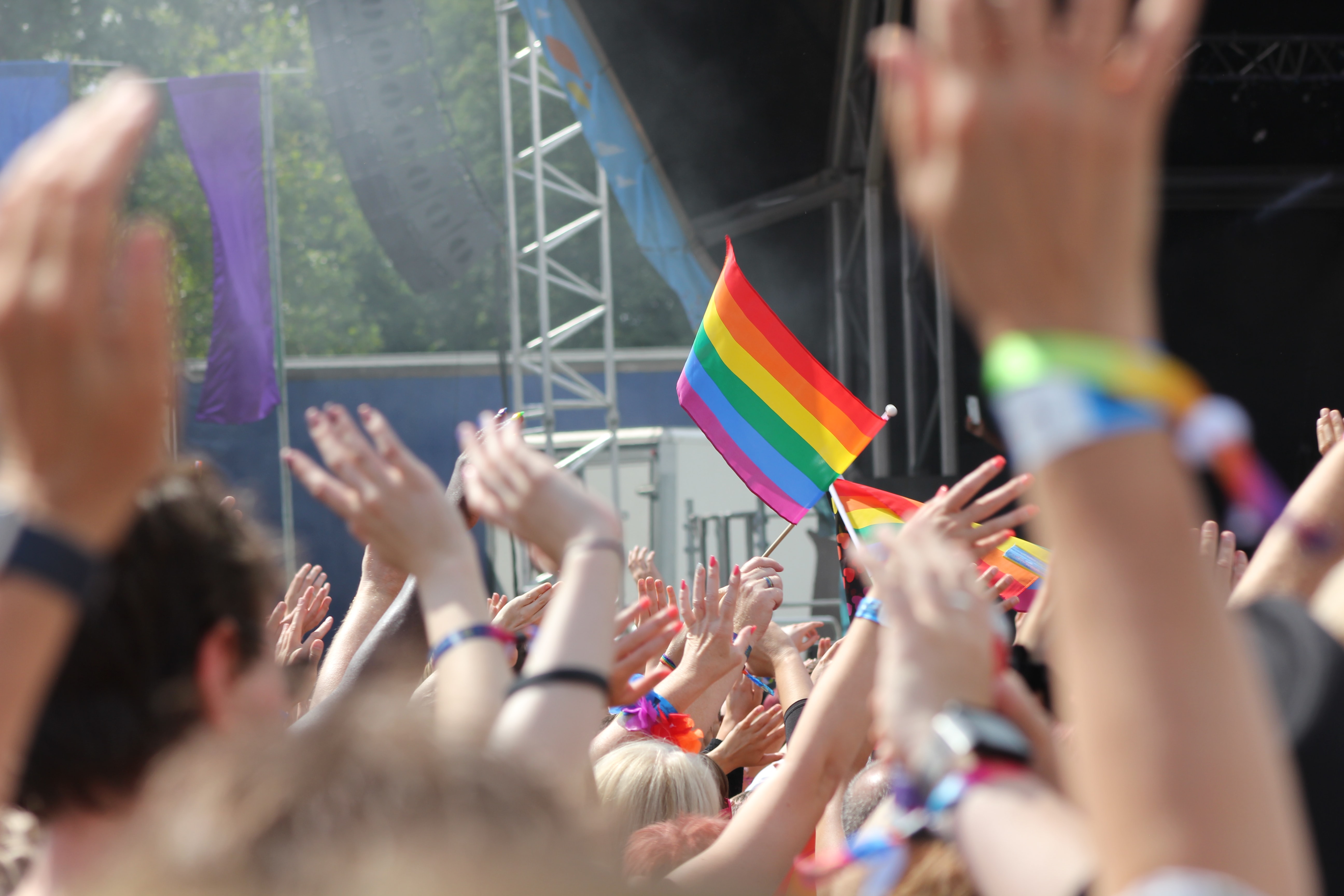 hände und regenbogen flagge bei gaypride