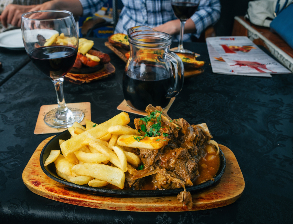 ziegenfleisch mit pommes und hausgemachter wein